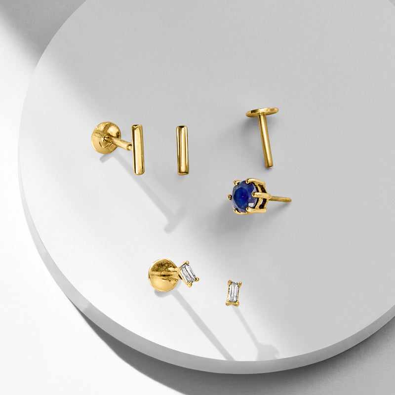 Yellow gold stud earrings display with square settings and small faceted gemstones