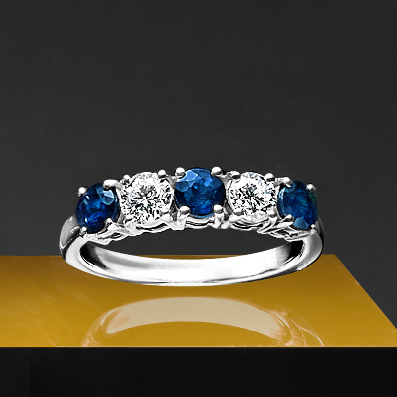 White gold ring featuring blue sapphire stones with clear diamond accents along the band