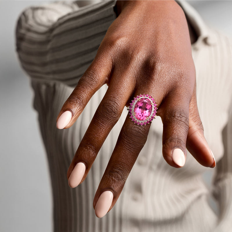Pink oval gemstone ring with ruby halo on 14kt yellow gold band