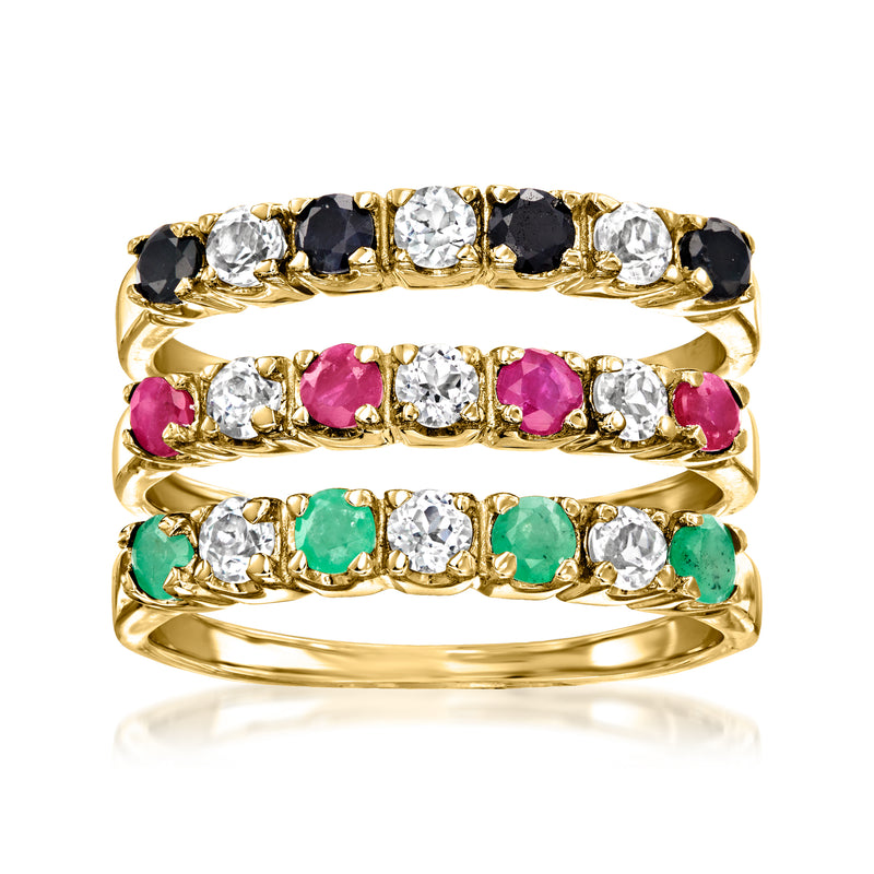 Three gold-tone stack rings with black, white, pink, and green gemstones.