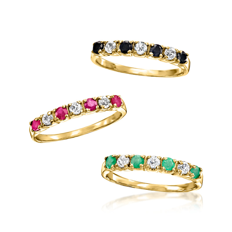 Three gemstone rings: black-and-white, pink, and green stones on gold-tone bands.