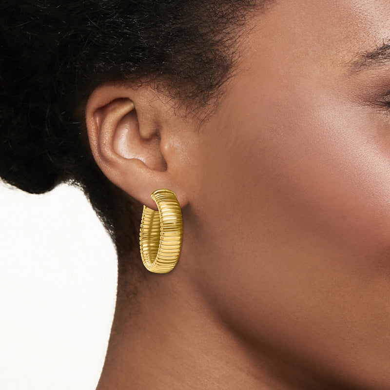 Ribbed gold tubogas hoop earring on ear, textured stacked curves