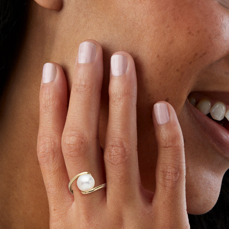 Cultured South Sea pearl ring in yellow gold on finger with oval white pearl