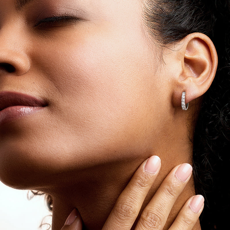 Huggie hoop earrings with lab-grown diamonds on the ear, sterling silver