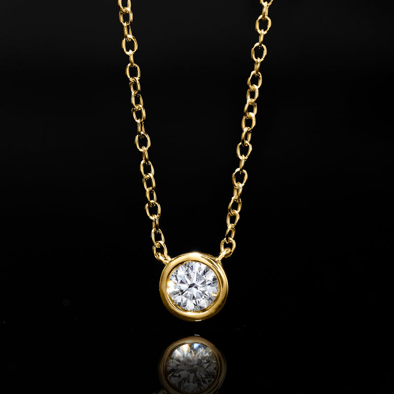 Gold necklace with round bezel diamond pendant and closely linked chain