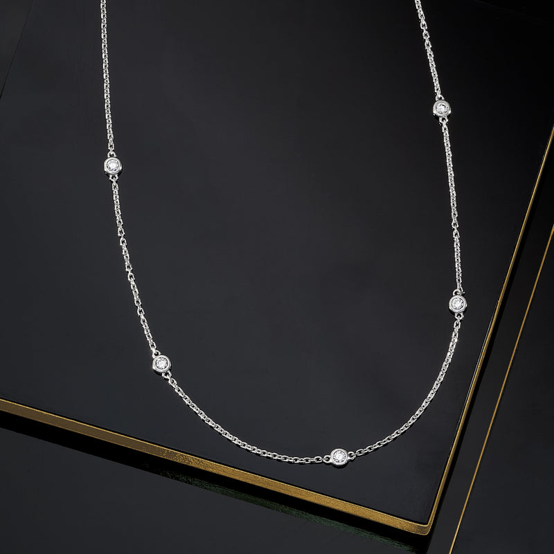 Sterling silver diamond station necklace with round stones set in stations on a cable chain