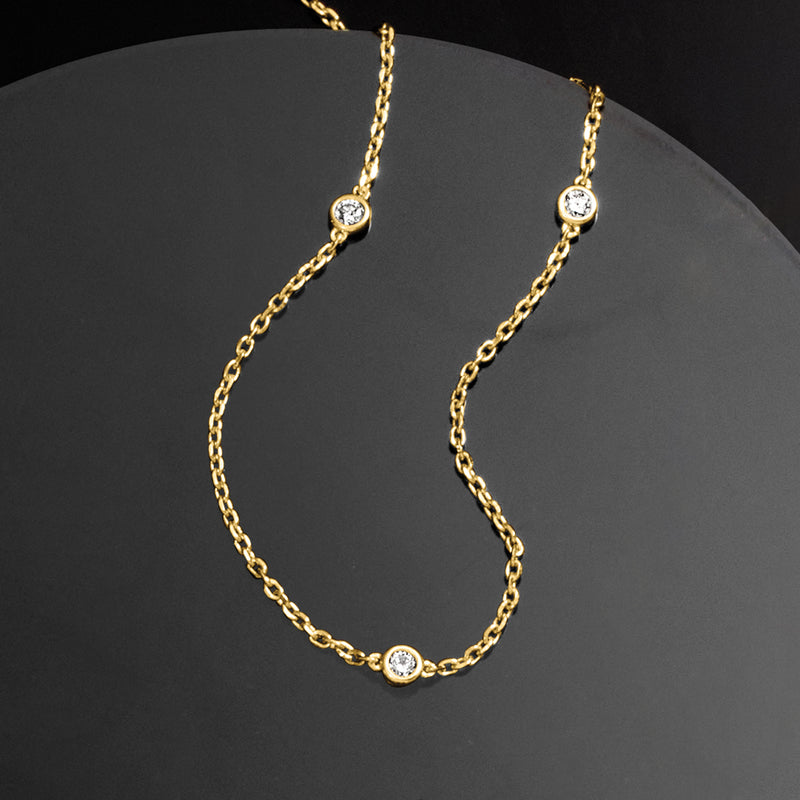 Gold station necklace with five round diamond stations on chain