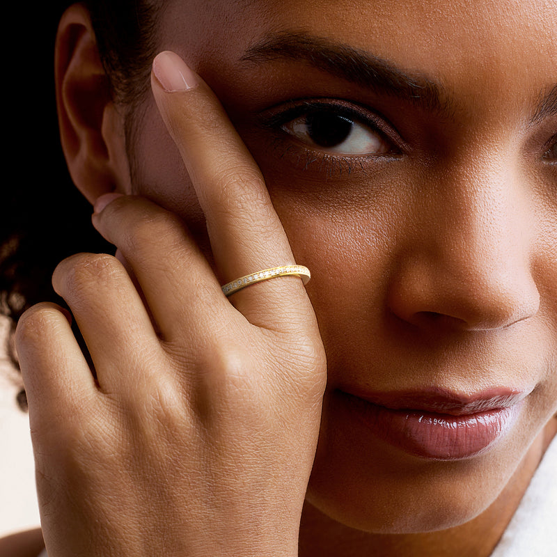 Lab-grown diamond eternity band in gold over sterling on model's finger