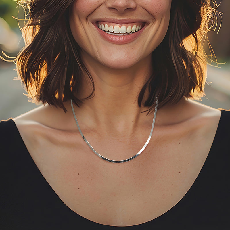 Sterling silver herringbone chain necklace worn on neckline