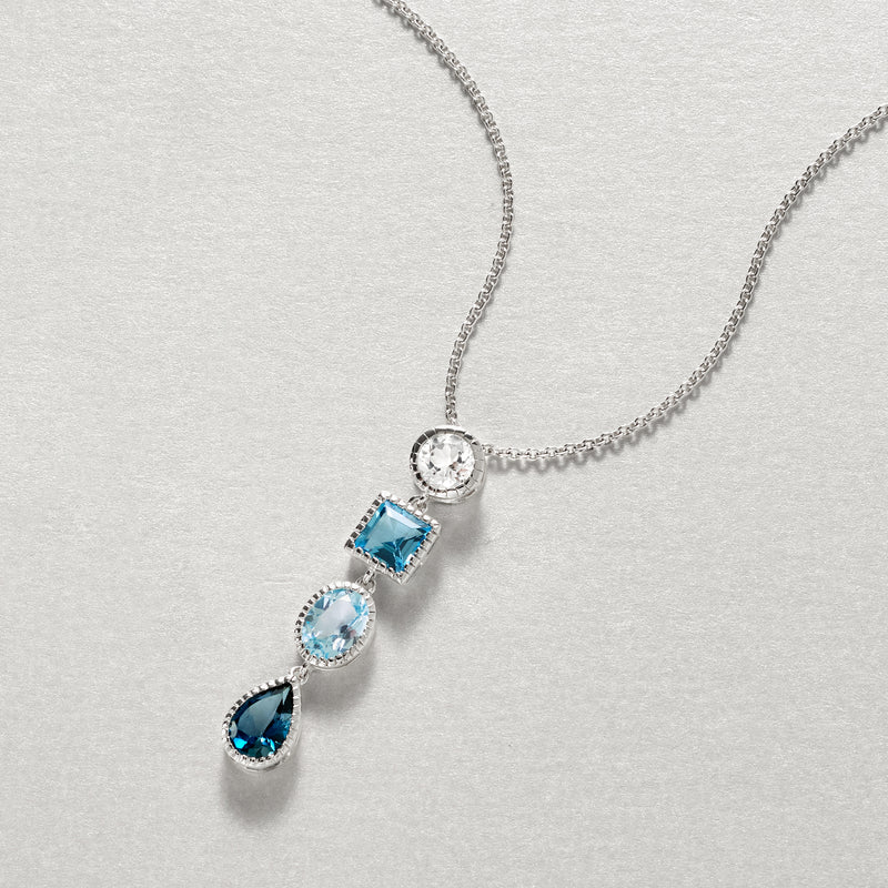 Sterling silver topaz pendant necklace close-up with square, oval, and teardrop blue stones