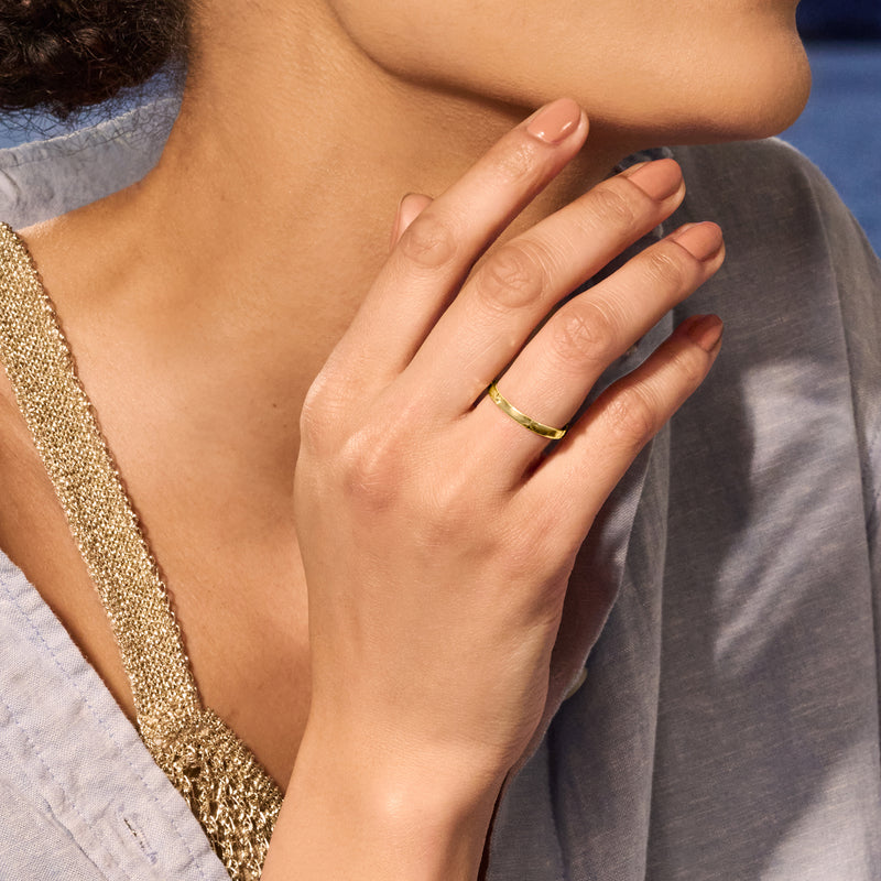 10kt yellow gold diamond-cut star ring worn on finger, slim band with star engravings