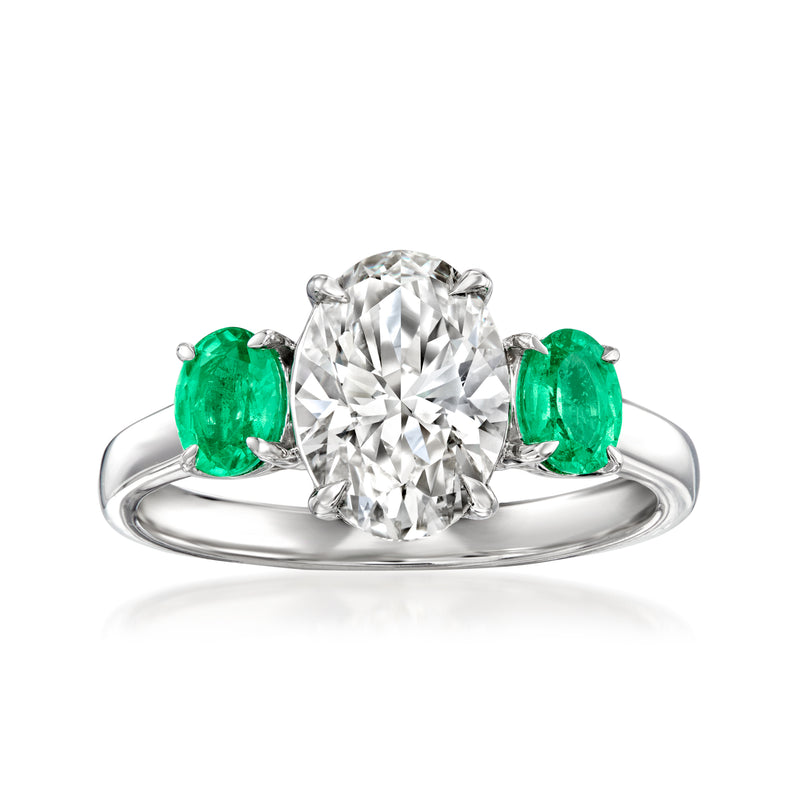 14kt white gold diamond ring with round center stone and 2 green emeralds