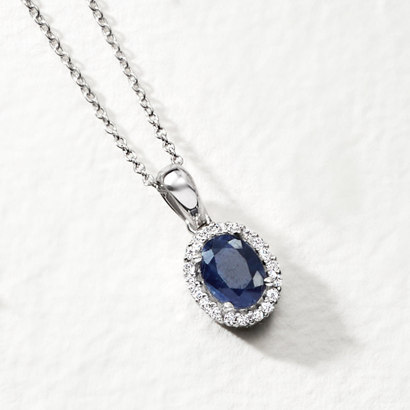 Sterling silver oval sapphire pendant with prong setting and halo of clear stones