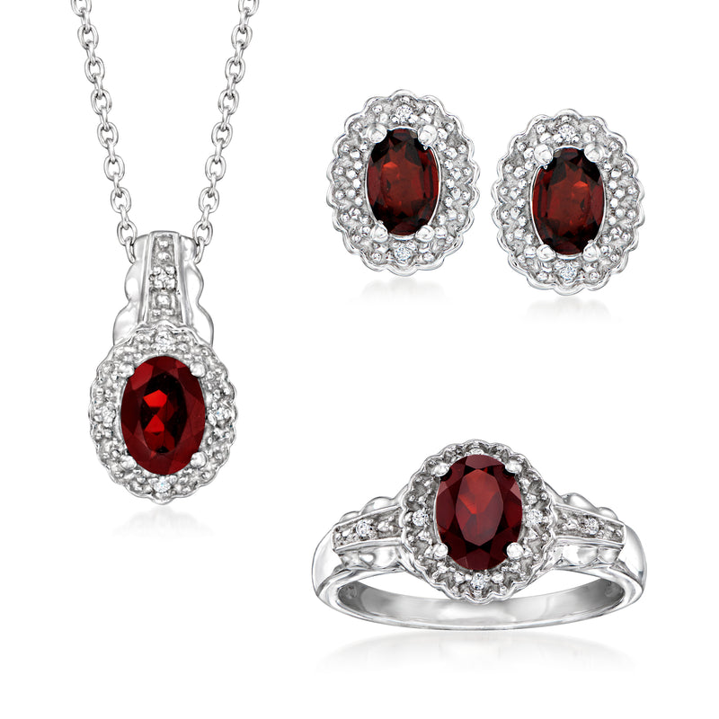 Sterling silver garnet jewelry set with red oval stones and white halos: pendant, earrings, ring
