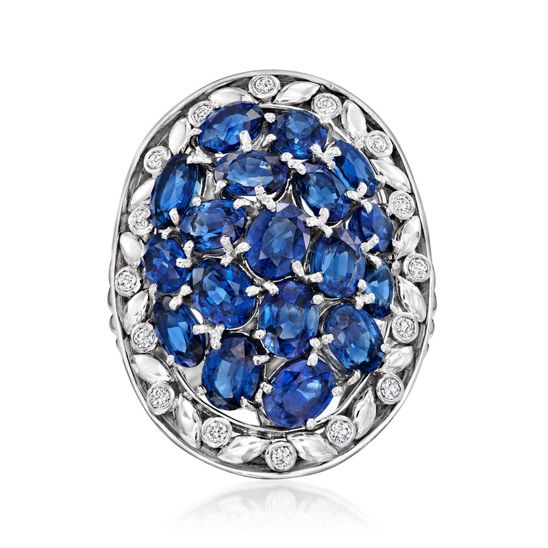 Oval cluster ring in white metal with blue sapphire center and small round diamond accents