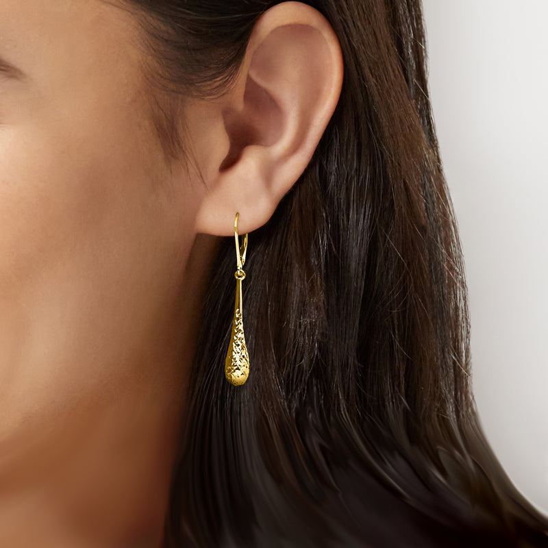 Teardrop dangle earrings in 10kt yellow gold on a model's ear, leverback closure