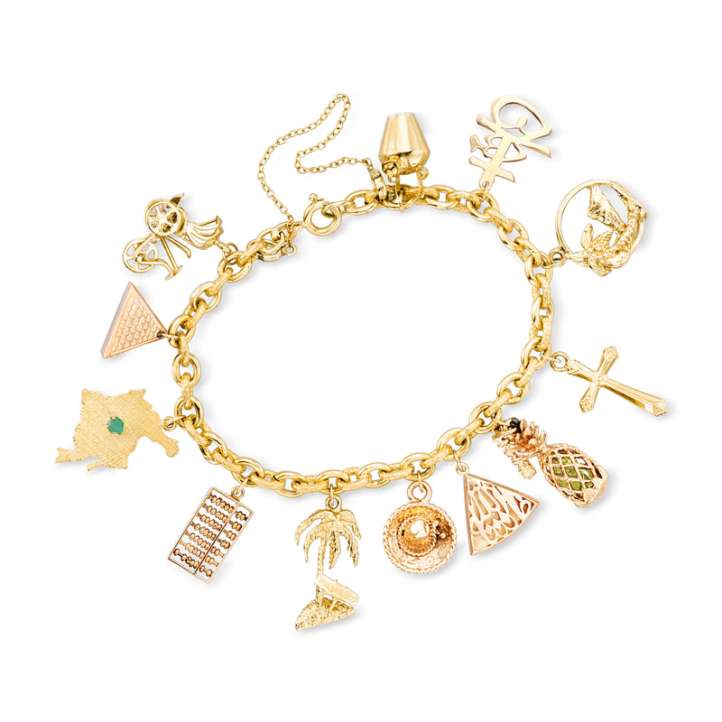 Vintage yellow gold charm bracelet with emerald and peridot accents and multiple charms