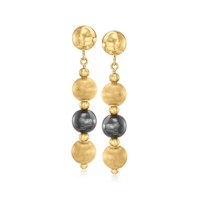 Vintage gold and dark gray bead drop earrings with round textured caps, dangling.