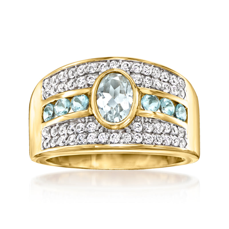 Gold tone ring with round aquamarine center stone, pale blue side stones, pave accents