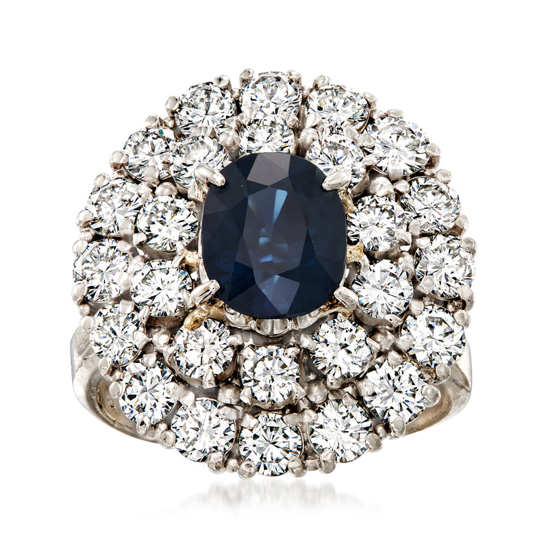 Platinum ring with dark blue oval sapphire center and round diamond halo setting