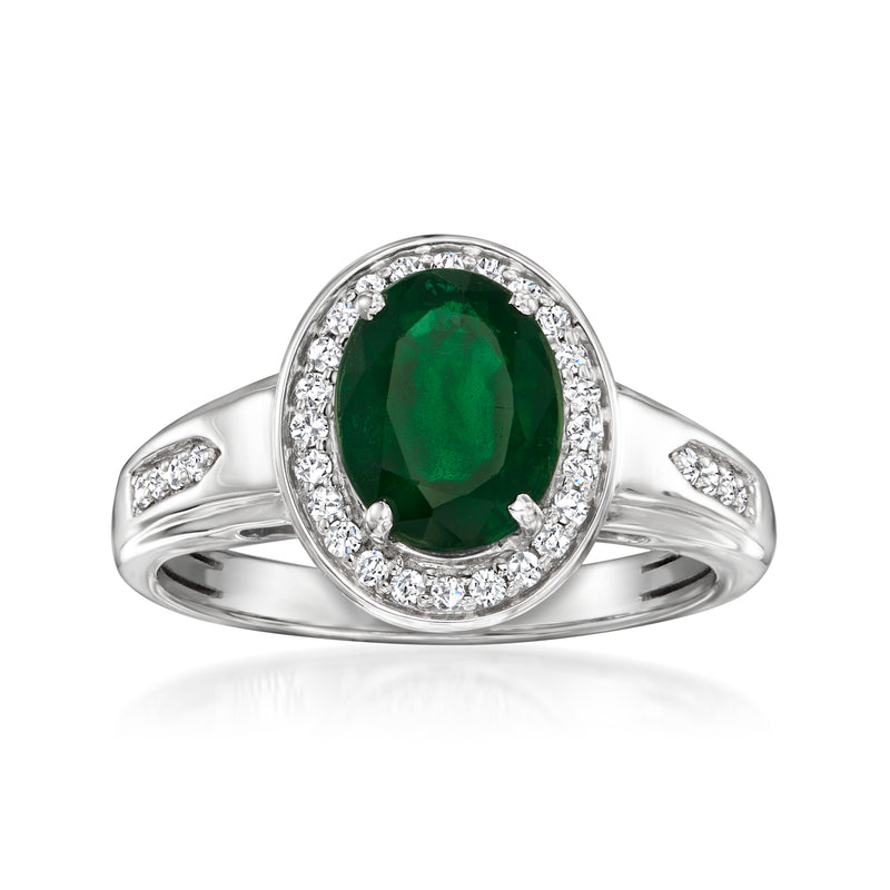White gold emerald ring with oval center stone, diamond halo, and side accents