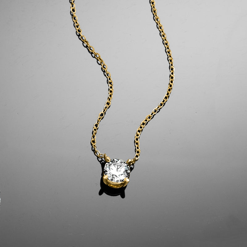 Gold solitaire diamond necklace with round center stone in prong setting and gold chain
