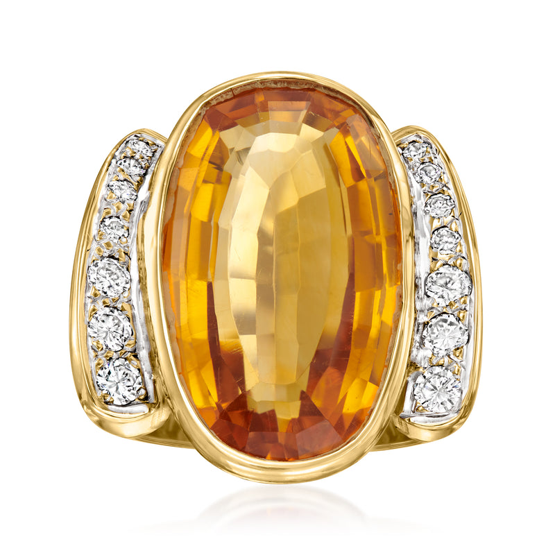 Oval golden citrine cocktail ring with diamond pave shoulders in 14k yellow gold