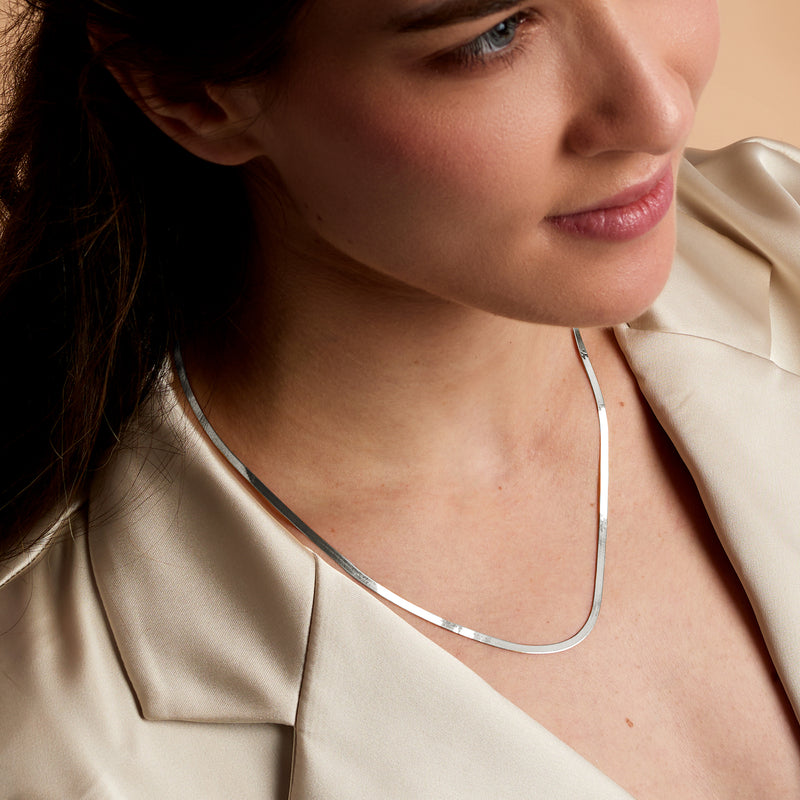 14kt white gold herringbone necklace on model, slim reflective links