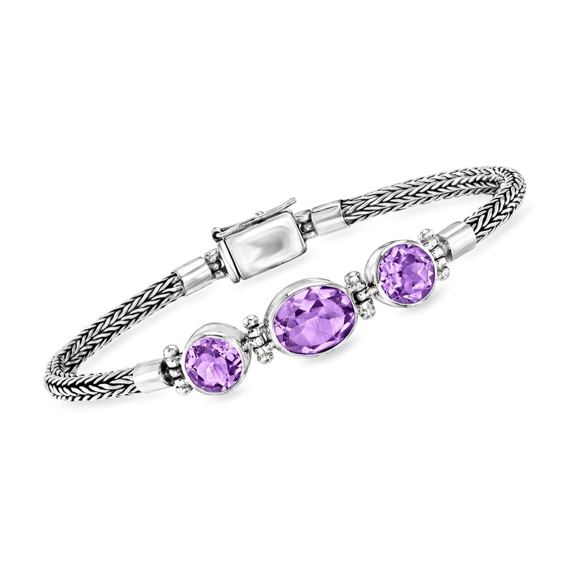 Sterling silver Bali-style bracelet with braided links and round amethyst gemstones.