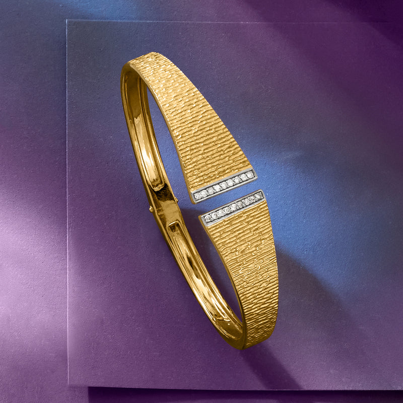 Gold cuff bracelet shown from side, textured band with two diamond stripe panels
