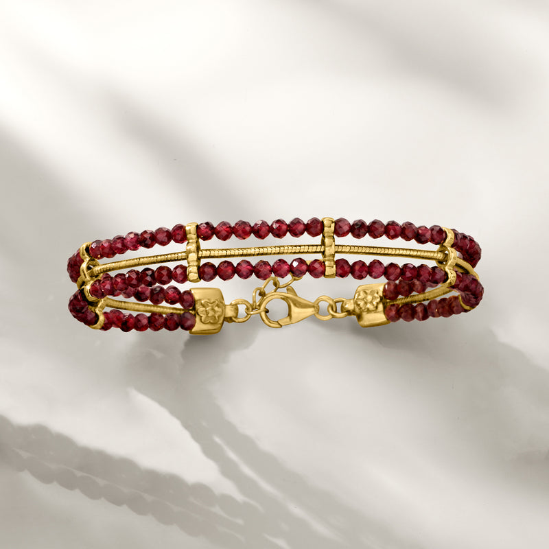 Garnet bead and gold snake-chain bracelet with toggle clasp detail