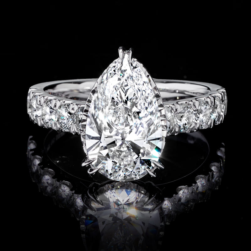Pear-shaped center diamond ring in white gold with round side diamonds