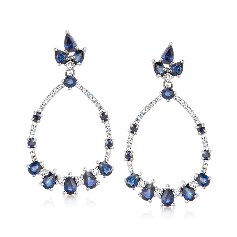 White gold sapphire and diamond drop earrings with circular blue gemstone halo and teardrop top