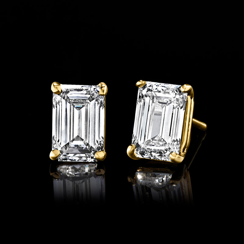 Emerald-cut diamond stud earrings angled view, yellow gold setting and faceted clear stones