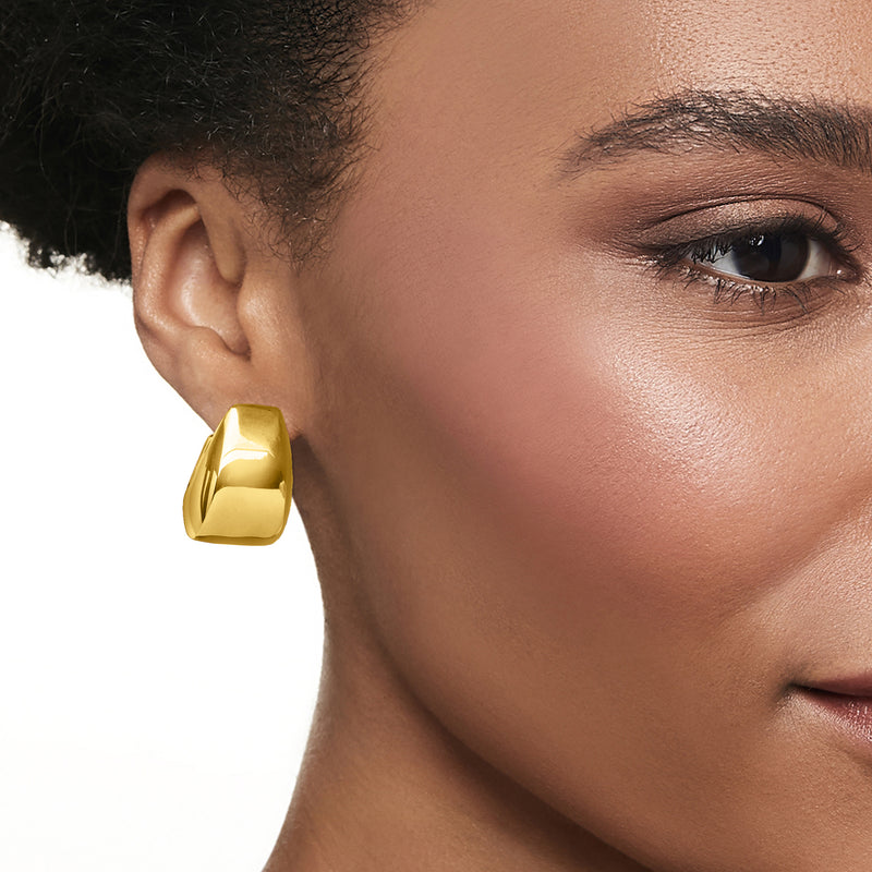 Gold graduated hoop earring on ear, close-up of hinged clasp