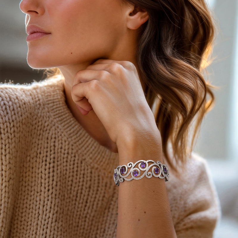 Sterling silver cuff bracelet with purple amethyst swirl design, worn on wrist