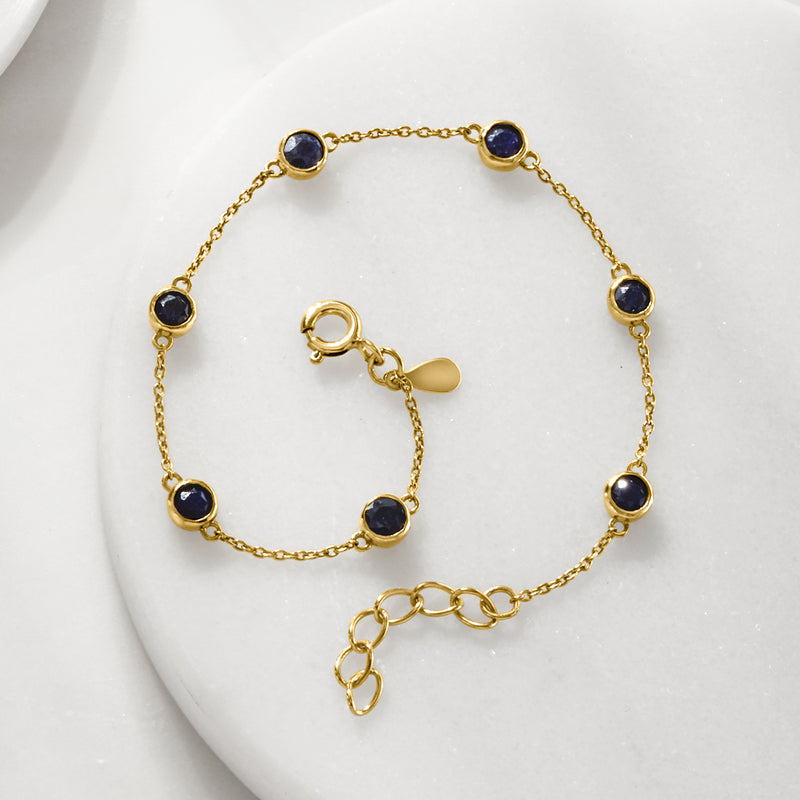 Gold chain bracelet with evenly spaced round blue sapphire bezel-set beads