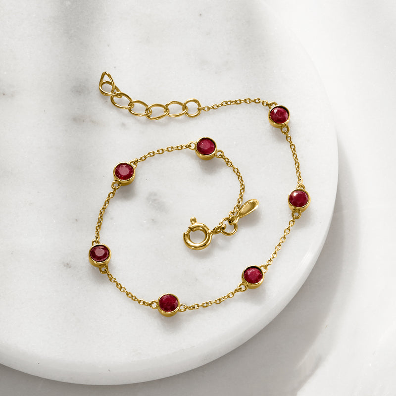 Gold link bracelet with bezel-set round ruby stations and spring-ring clasp
