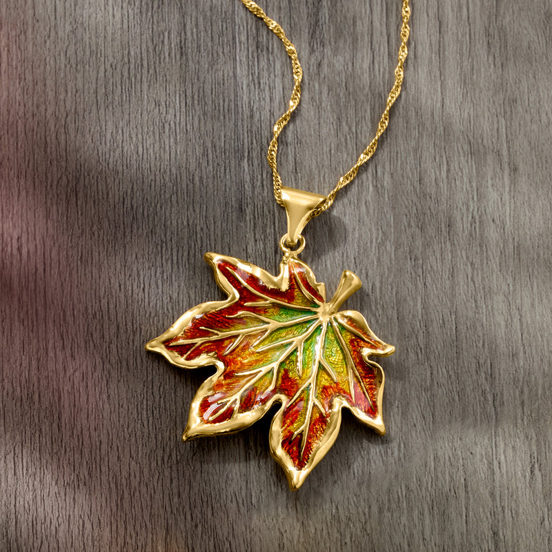 Gold chain necklace featuring a multicolored enamel maple leaf pendant