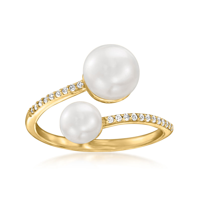 Gold bypass ring with two cultured white pearls and clear gemstone accents.