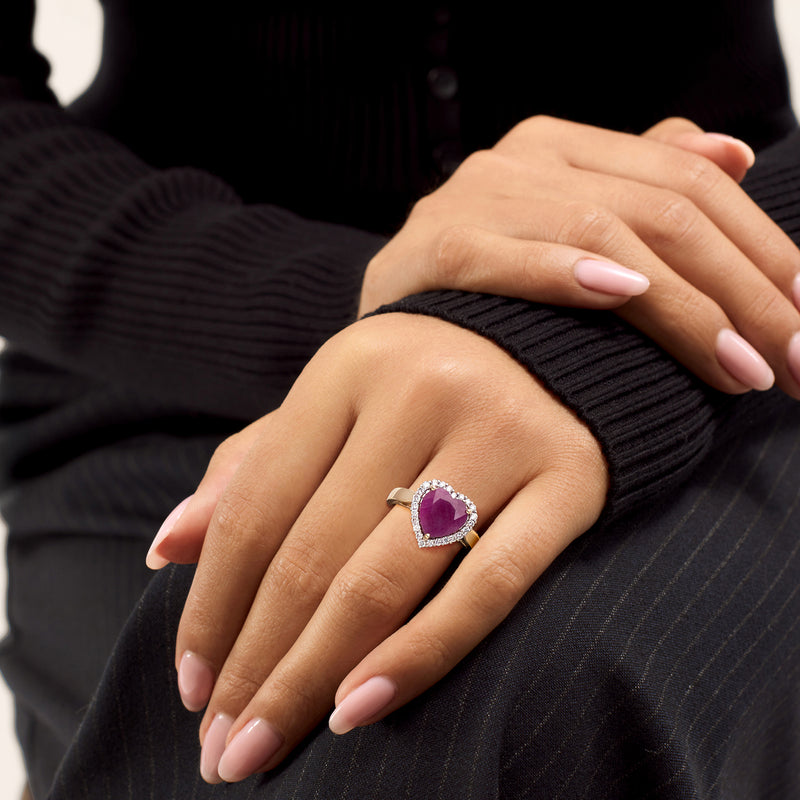 Heart ruby diamond halo ring on hand with 14k yellow gold band