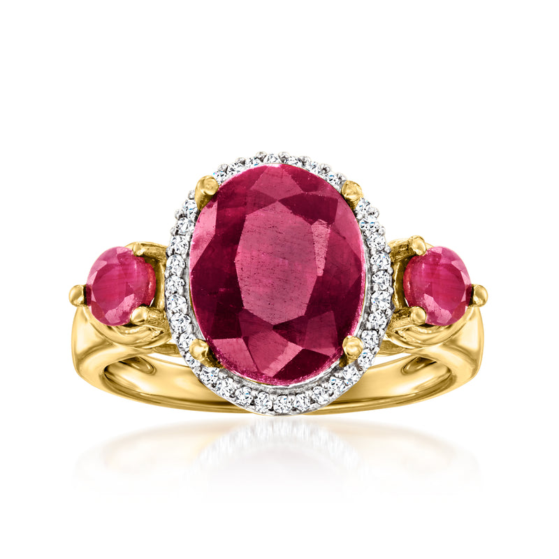 Oval ruby and diamond halo ring with three gold prongs and side ruby accents