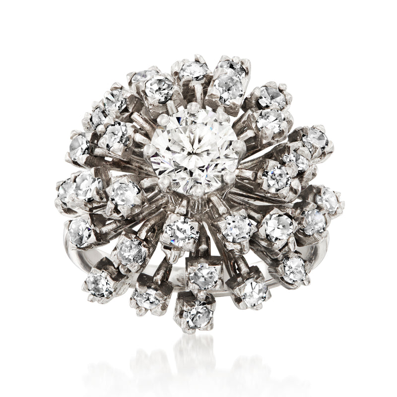 White gold diamond cluster ring with round center stone and radiating smaller diamonds.
