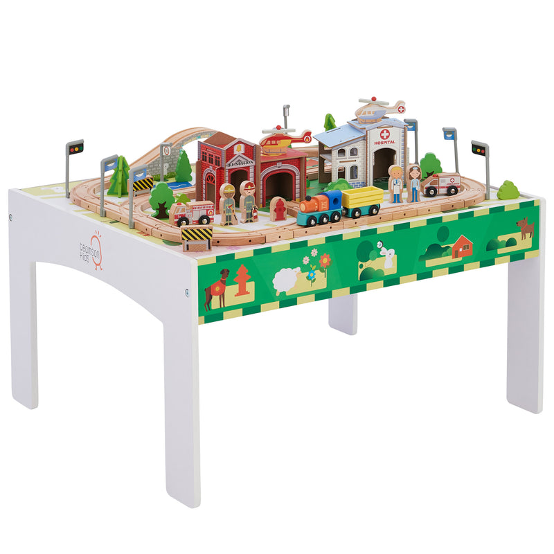 White kids train and table set with colorful track pieces, buildings, trees, and vehicles