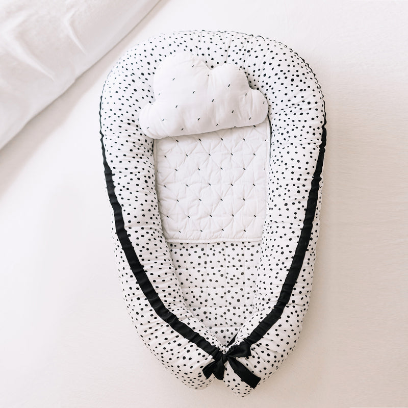 Black and white polka dot cotton baby napper with quilted padded center and bow ties
