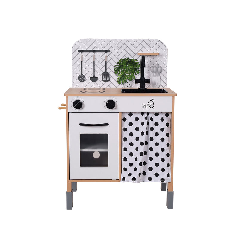White wooden kids play kitchen with oven door, stove knobs, and polka-dot side panel