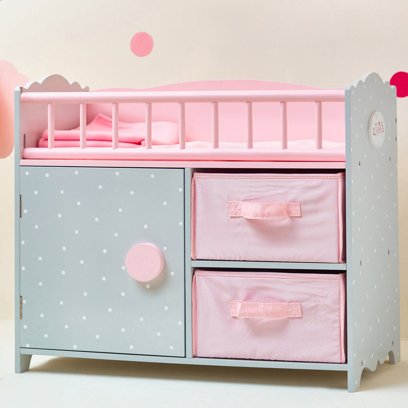Child's doll crib with blue polka-dot cabinet, pink top, and two drawer cubbies