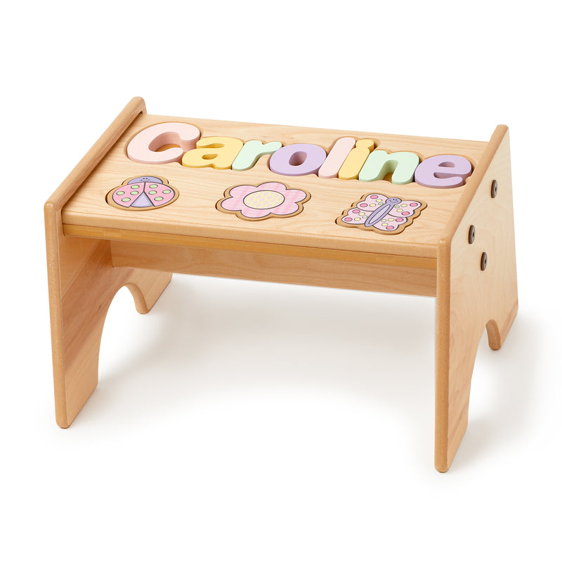 Wooden puzzle stool with pastel flower inlays and raised name letters on top