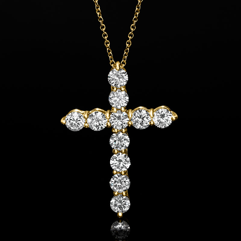 Yellow gold cross pendant with round diamond clusters and dangling vertical stones