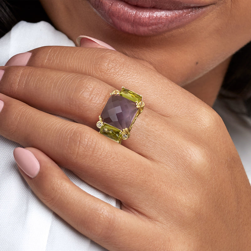 Gold-tone square-cut amethyst and green peridot ring with white topaz accents on finger